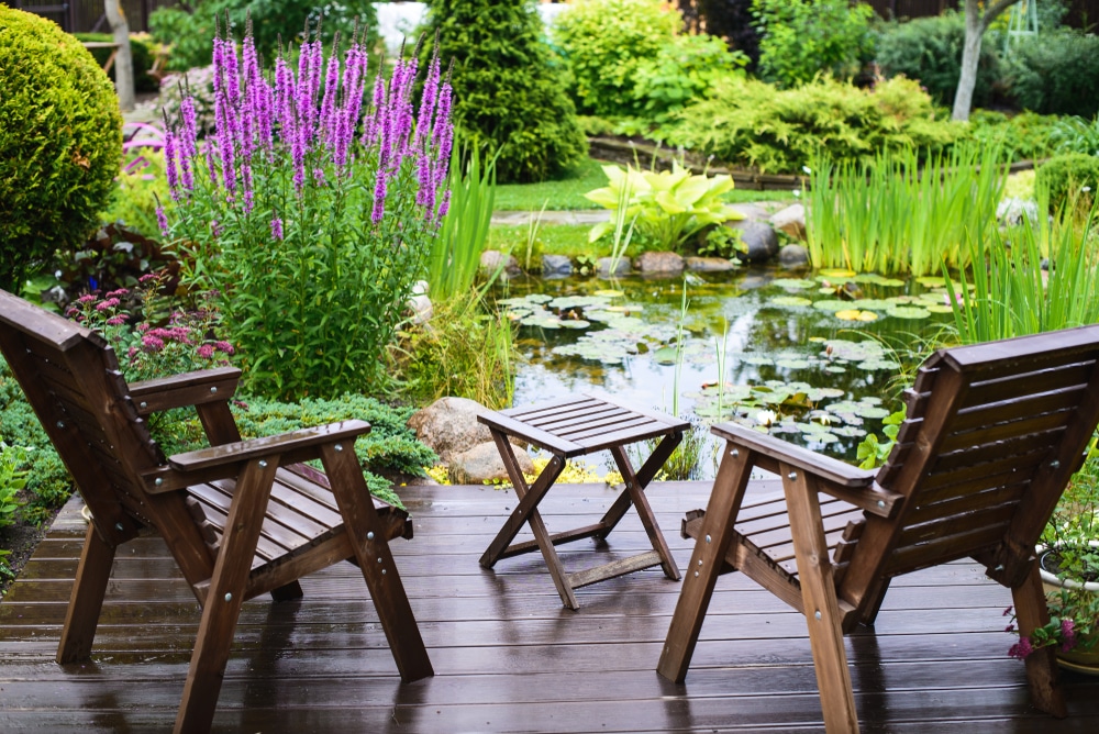 jardin terrasse avec chaises et table devant un petit étang